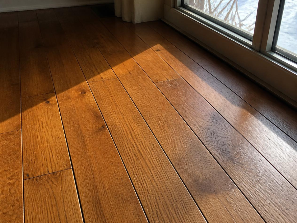 Seasonal gaps between boards on a hardwood floor installation in a Denver home during dry winter heating season