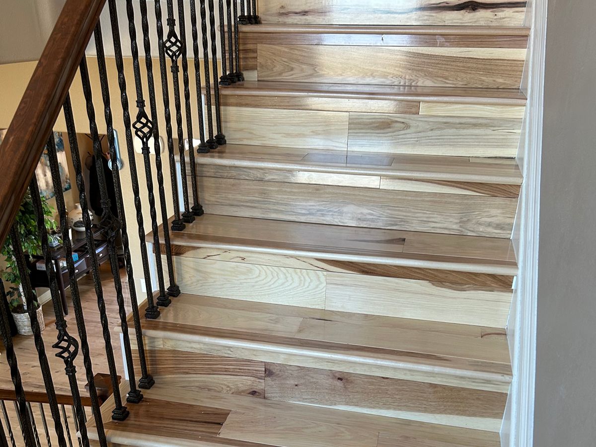 Hardwood floor installation in a Denver home with new boards going down over a checked subfloor